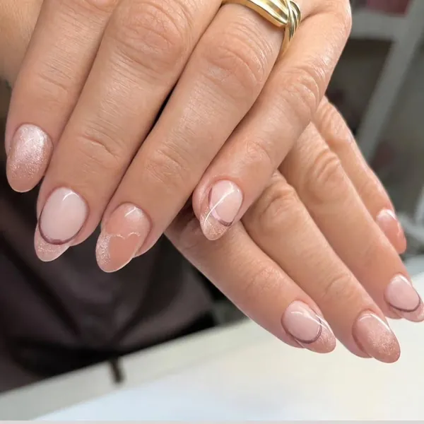 Nude amandelnagels met dunne lijntjes en een glitternagel