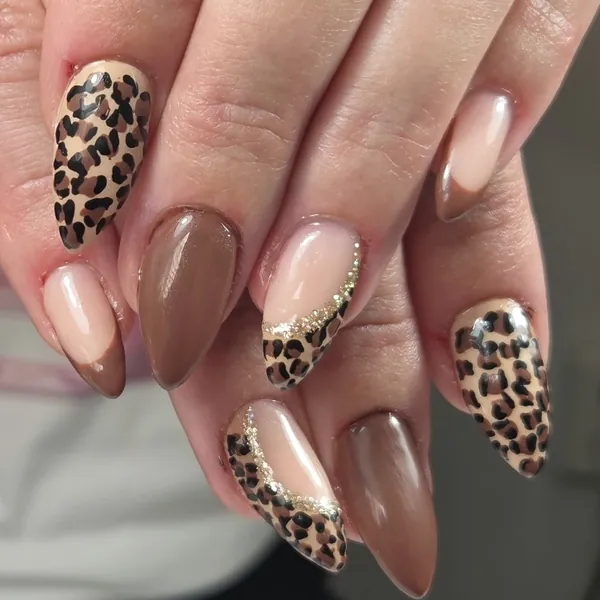 Amandelnagels in nude en bruin met luipaardprint en een gouden glitterrand